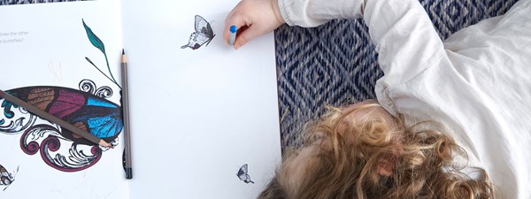 Little girl colouring in with pencils