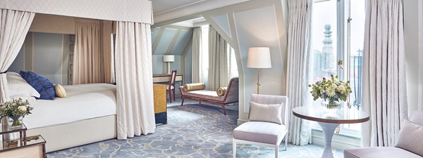 The bedroom of The Apartment at The Connaught with a bed on the left, a small table and two chairs on the right